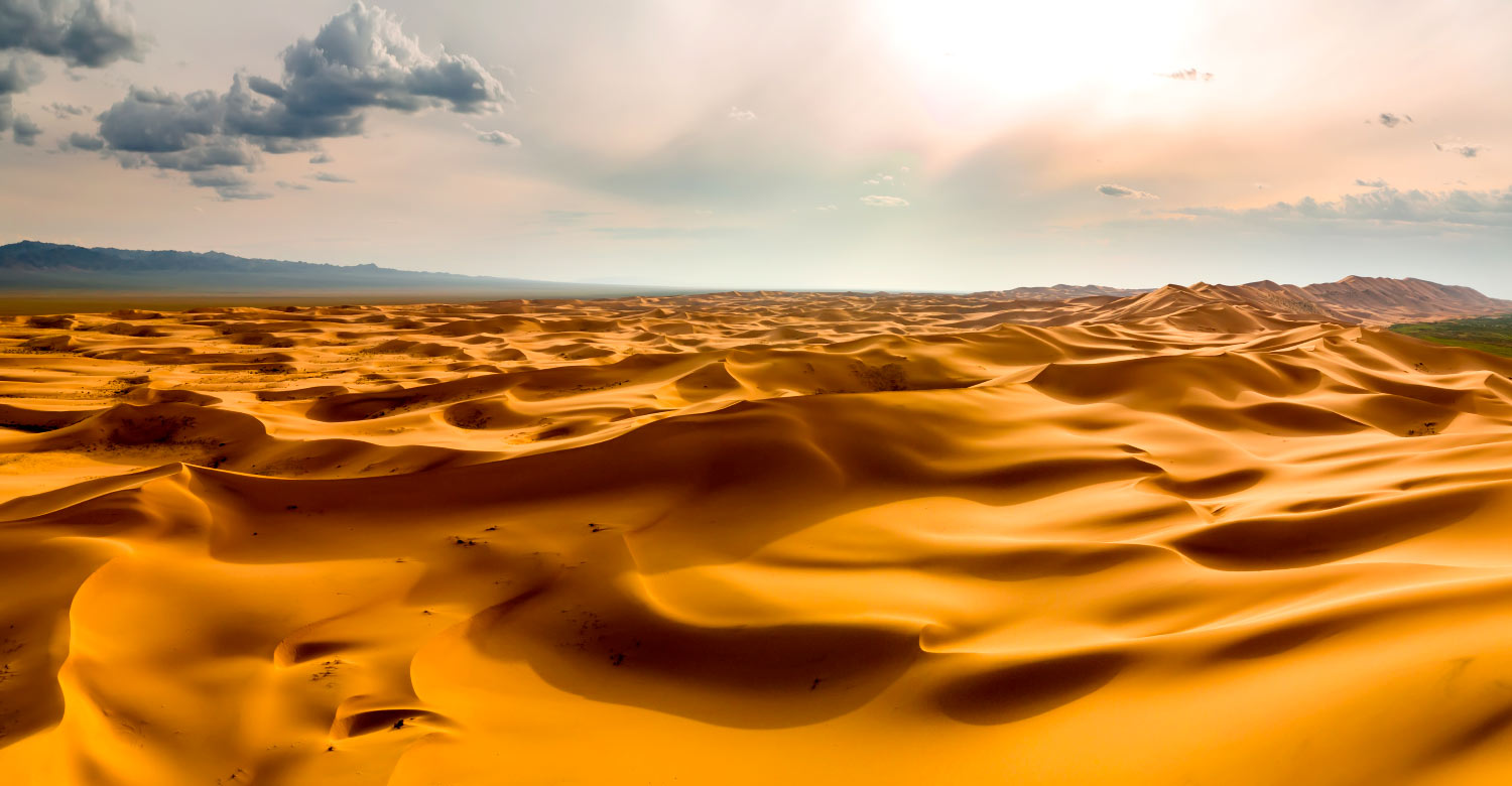 Sunset over the sand dunes in the desert.