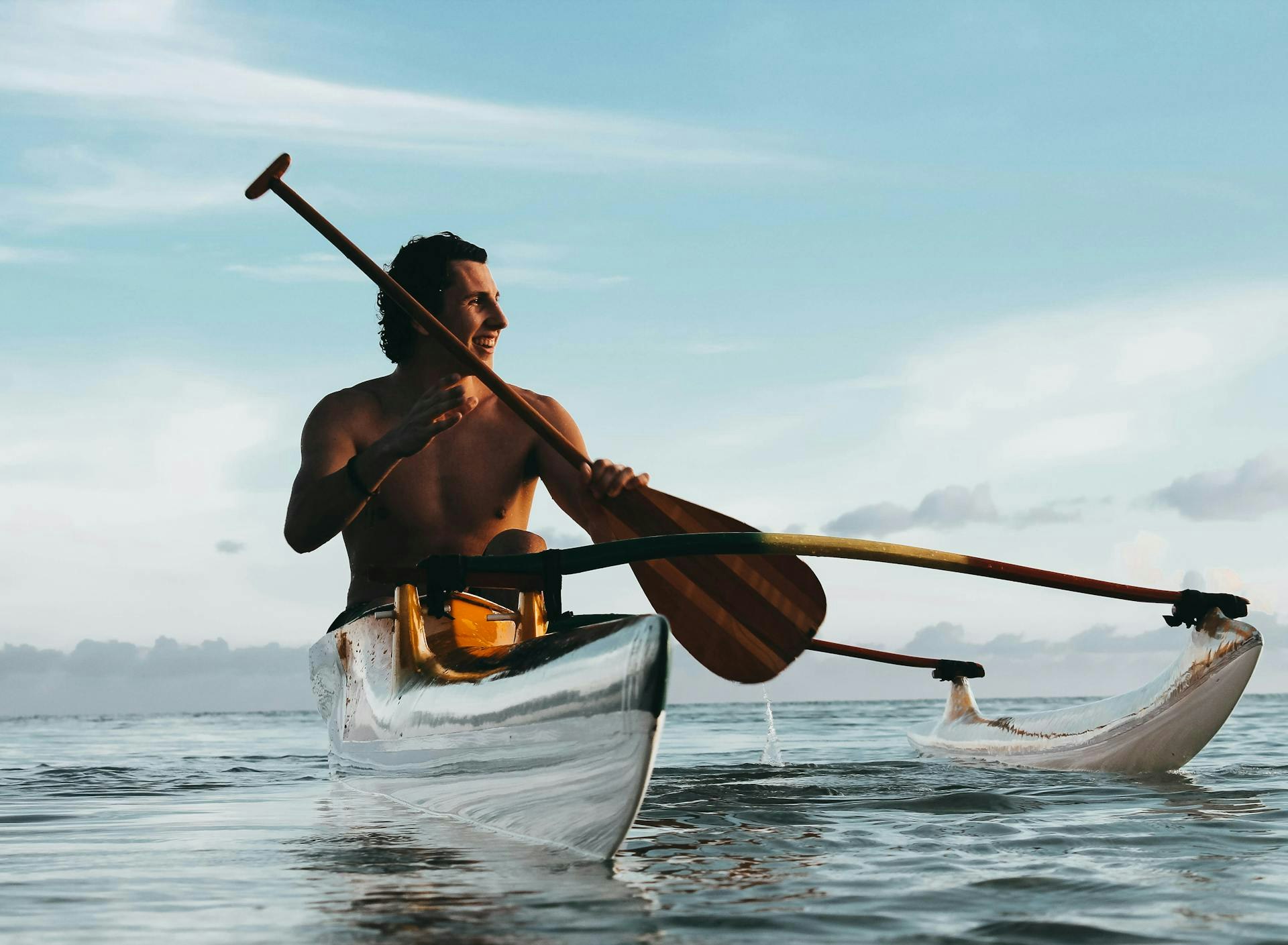 Man holding a paddle while riding a kayak in the sea