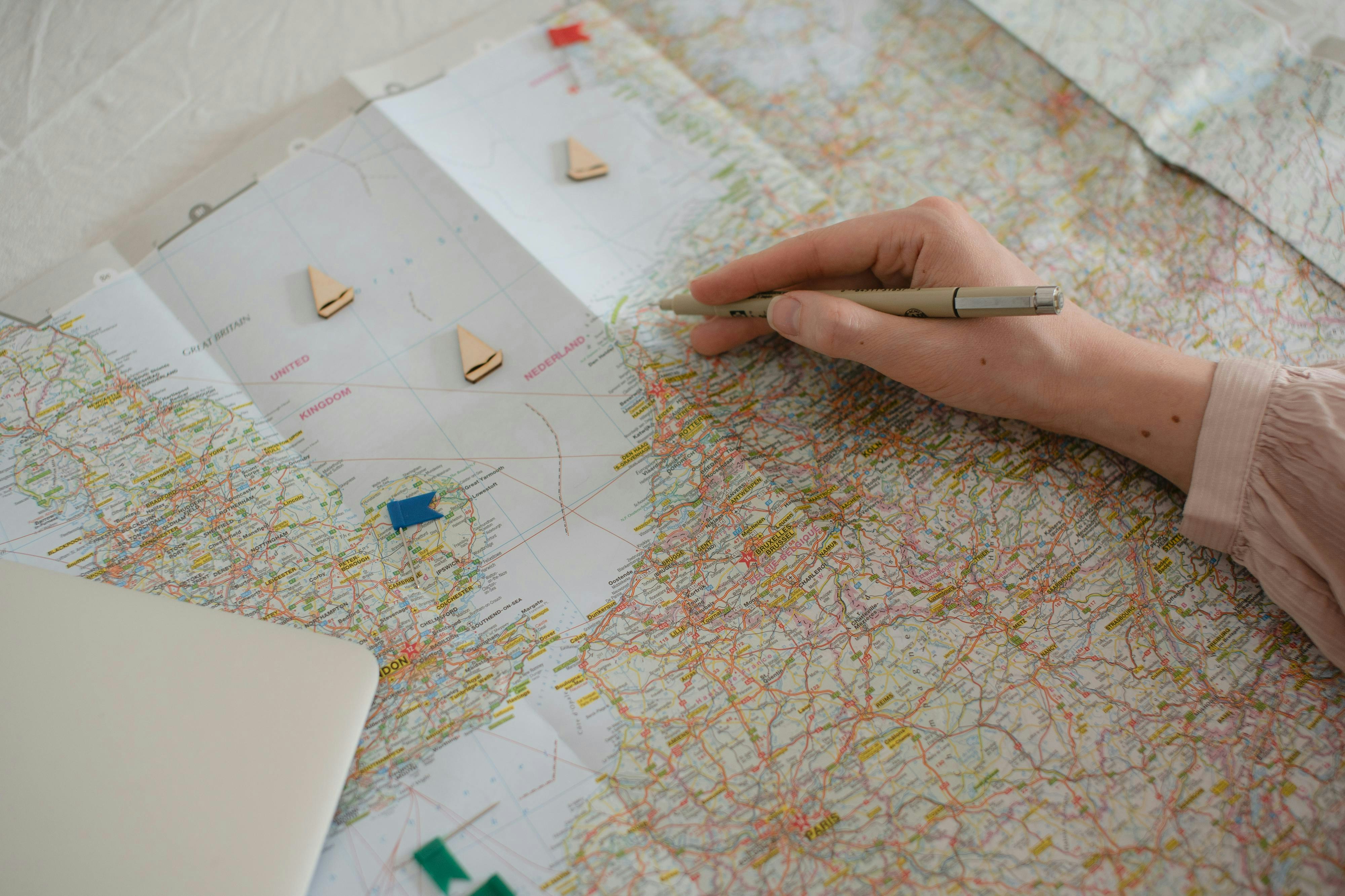 A person holding a pen over a map