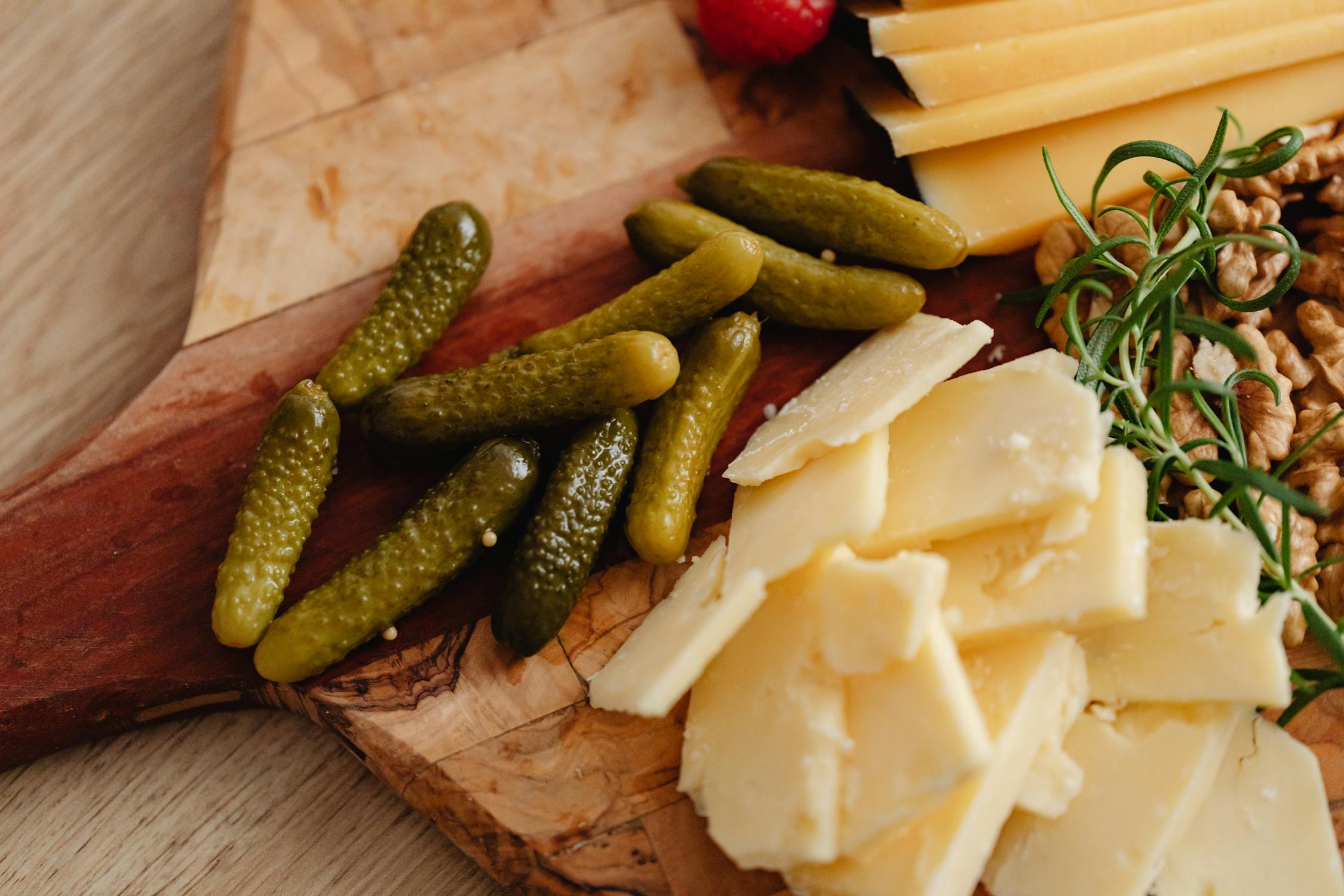 Close-Up of Green Pickles Beside Slices of Cheese