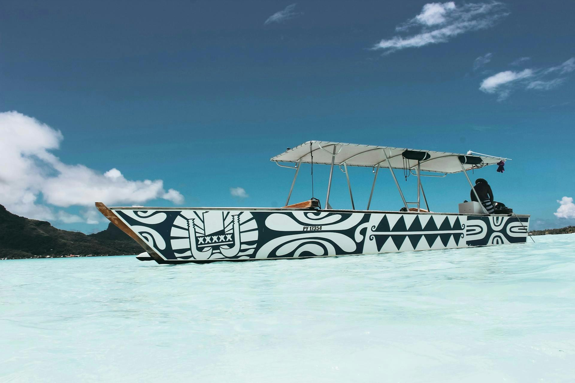 Person sitting on a boat in the sea under a clear sky